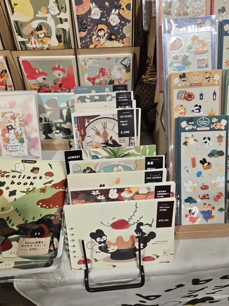 明信片樣品的陳列方式很棒，有質感又方便參閱作品。有的是用紙貼紙黏起來，有的是用打洞的方式將明信片放再一起。