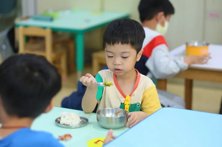 （圖說：接受早療服務後，皓皓已能自行吃飯，並嘗試各式料理。）