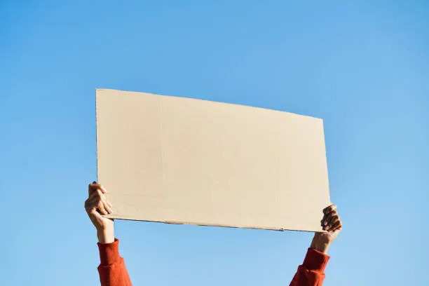 Unrecognizable woman's hands holding a protest banner with no message, with the sky in the background. Photograph: Alvaro Medina Jurado/gettyimages