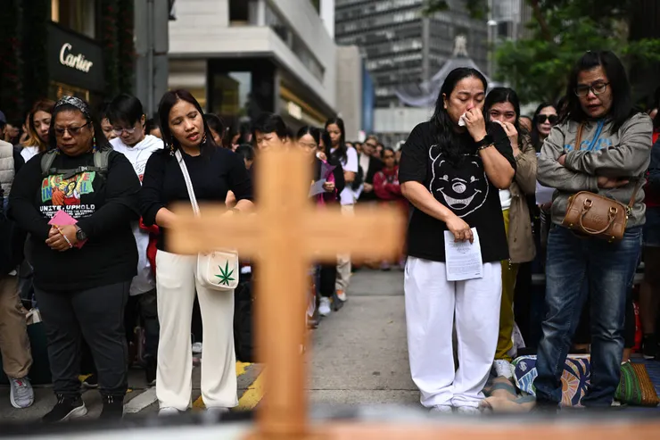 菲律賓人在香港參加社區祈禱活動，悼念11月26日大埔火災的遇難者。 Philip Fong/Agence France-Presse — Getty Images