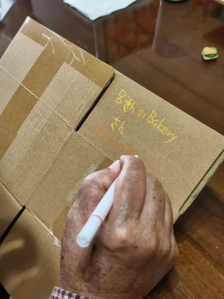 練習寫一遍麵包店的招牌名字，等一下要真的寫上招牌囉!