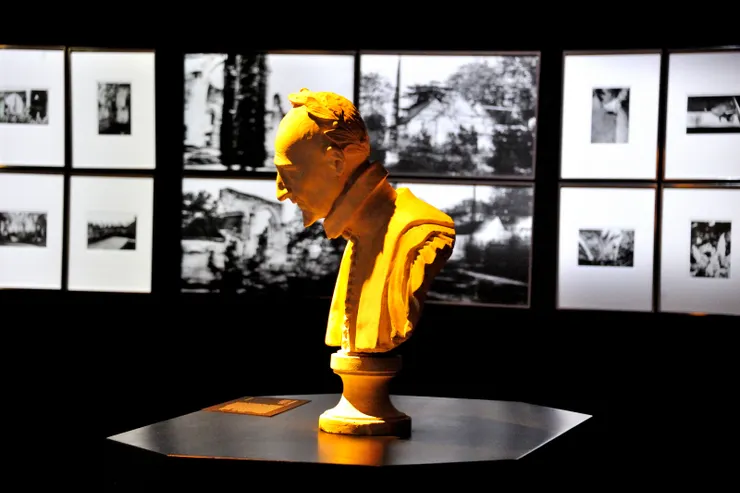 【教士食堂內部，龍薩雕像，背景為修道院歷史照片。】