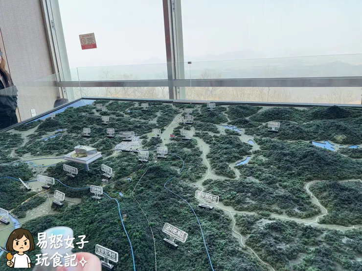 拍地景模型隱隱約約看得到後面窗外的北韓