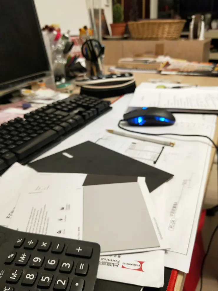 甫與客戶開完會,桌上滿布的圖紙與樣品。