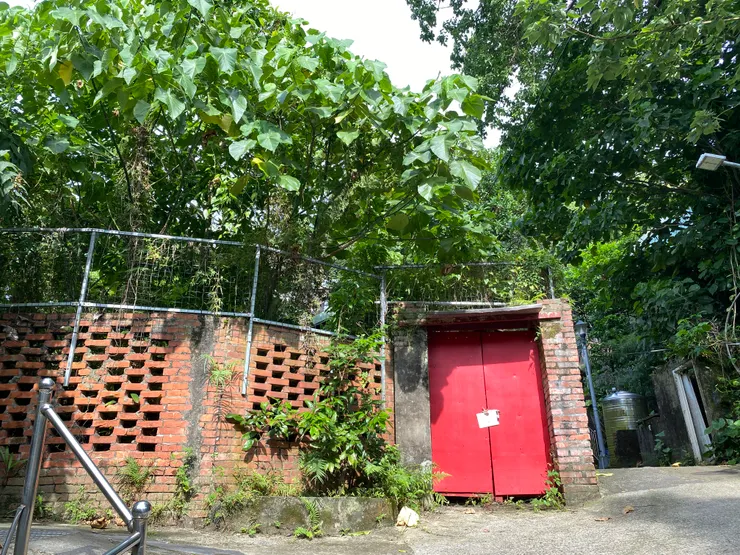 穿出這道磚牆巷弄之後，會看到一個陡坡。旁邊就是從前的陸軍道（拍攝日期：2025/7）