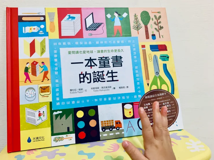 想拍攝書籍封面，孩子的小手悄悄入鏡。