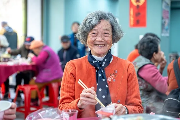 碧珠阿嬤打扮體面，一起入席，準備圍爐吃飯。