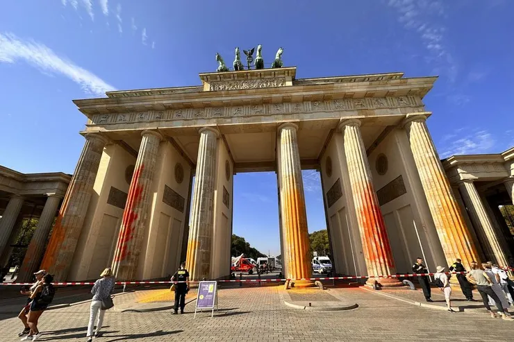 Member of the climate protection group Last Generation have sprayed the Brandenburg Gate with orange paint (Paul Zinken / dpa via AP)