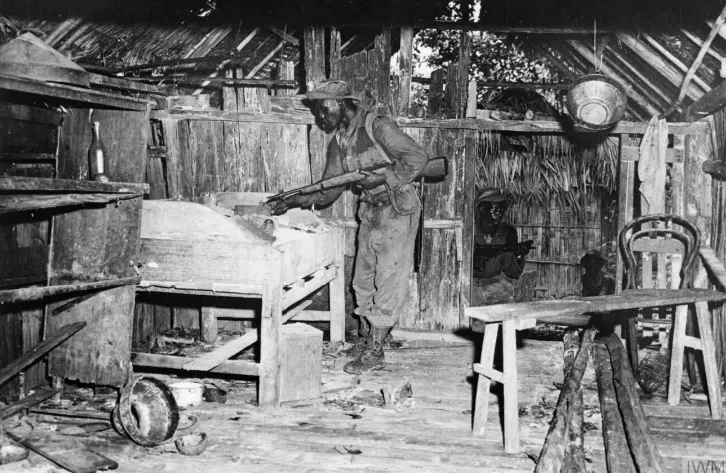 馬來亞緊急狀態期間，皇家非洲步兵團的肯亞士兵正在搜查一馬共游擊隊廢棄小屋。-英國帝國戰爭博物館（Imperial War Museum），檔號：K14004。