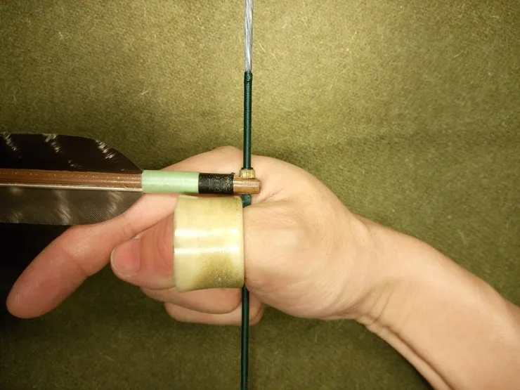 饅頭面磨成平的，筒扳指軸線與箭平行，饅頭面扣弦與引弦方向垂直。