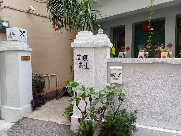 白色外牆很顯眼,門口小庭院的植物們為店家增添了不少生氣。