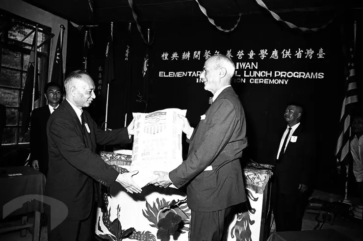 圖4 省主席黃杰(左)自美國駐華大使賴特(右)手中接過美援贈與麵粉袋 案名:1964農復會照片 檔號:0053/0011/1 來源機關:行政院新聞局 管有機關:國家發展委員會檔案管理局