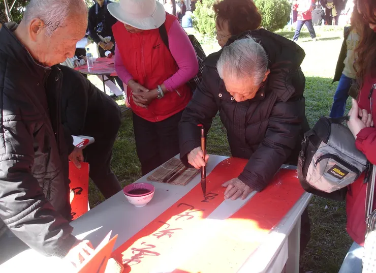 書法大師[黃群英]寫春聯分贈民眾 ([陳傳義]拍攝)