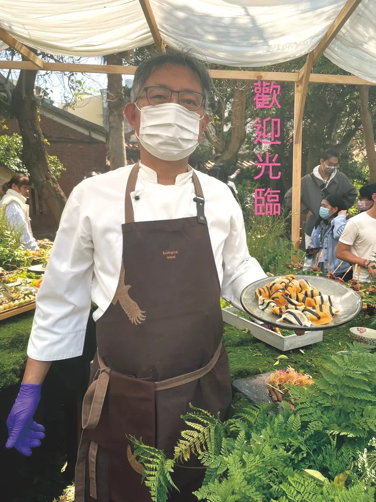 ▲胡立國穿生態廚師象徵的台灣林鵰圍裙，手上端著他利用西海岸的物產珍珠蚵，結合新鮮食保存食發酵食的發想設計的韭菜蚵仔水餃。（照片提供：胡立國）