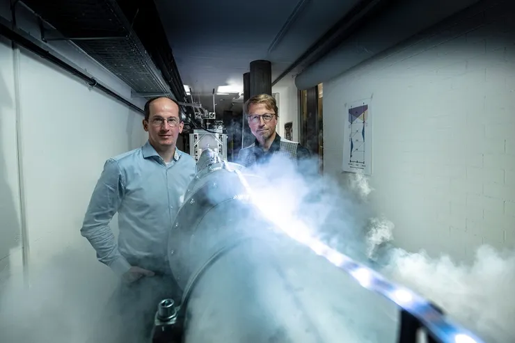 畫面左側為 Andreas Wallraff 教授，他帶領的團隊在 2023 年利用這條長達 30 公尺 的低溫超導線路（管狀設施），成功演示了超導位元間的遠距離量子遙傳。