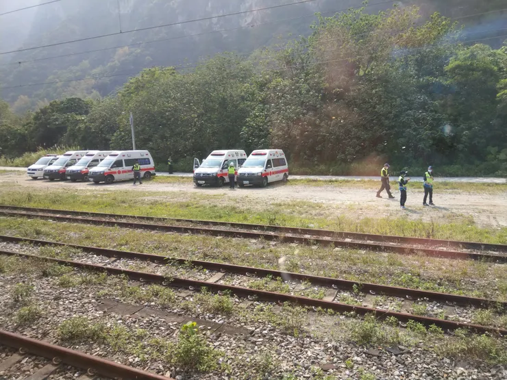 過清水隧道，火車減速暫停，可看到數輛救護車，有些救護人員正走往隧道方向。