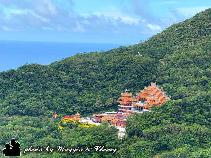在綠意滿滿的山谷間，突然冒出一座超壯觀的廟宇 🛕✨ 紅橙色屋簷在綠林包圍下好顯眼，背後還有藍藍的大海陪襯，真的像一幅畫一樣。  走在這裡，感覺特別寧靜，空氣清新，心情也跟著放鬆下來 💚 台灣真的處處都有小驚喜，隨便一轉彎就是一個美景。