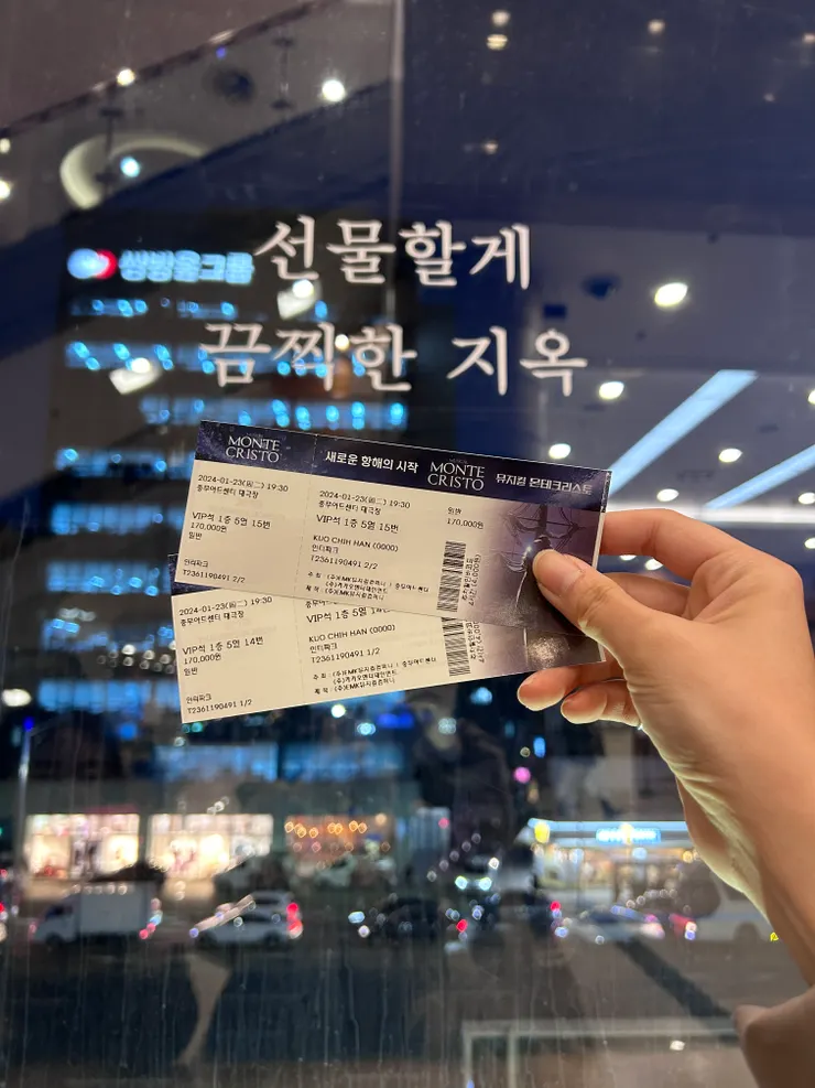 和音樂劇門票合照，窗戶上面寫的是地獄頌的經典歌詞