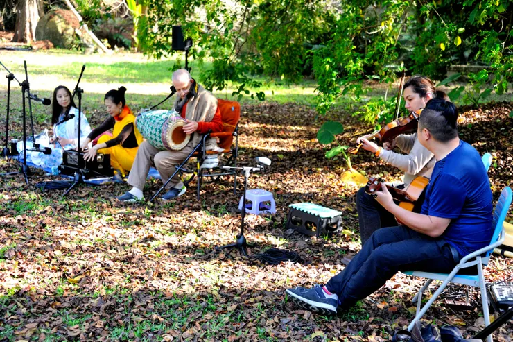 【新加入的樂手讓伴奏層次更豐富！此時古茹打著木丹加鼓，右側兩位是新近加入的小提琴、吉它專業樂手，也擅長布置音響系統。】