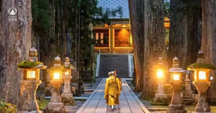 兩位僧侶步行於高野山奧之院石燈籠夾道的古道上