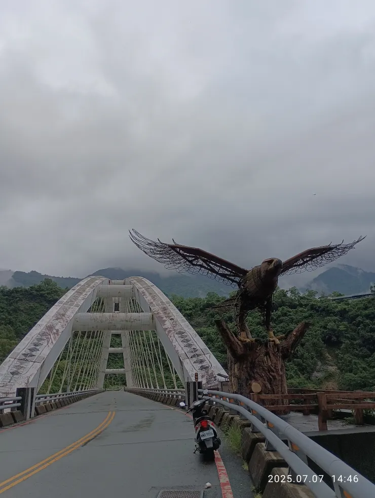 多娜橋，旁立黑鳶鐵雕，單騎摩托