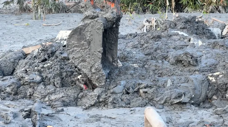 怪手在泥濘中尋找災戶的財務