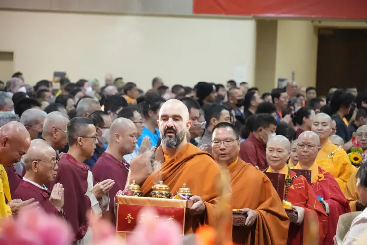 聖德們雙手捧著《南無第三世多杰羌佛經藏總集》 呈供