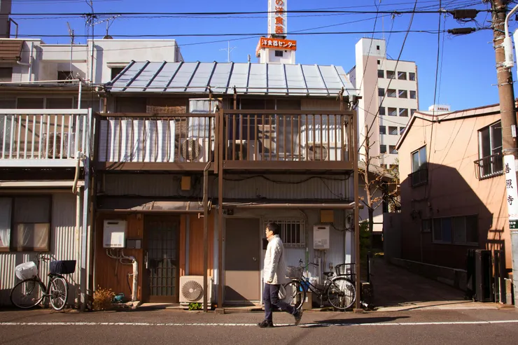 日本老舊住宅外觀實況，象徵帶租約物件（Owner Change）難以親自內覽、室內屋況未知的潛在投資風險。