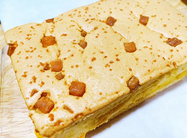 初蛋糕質感金黃禮盒內裝著整塊德國起士豆漿蛋糕，表面烘烤出漂亮的自然金黃色澤，呈現職人手作的紮實分量感。