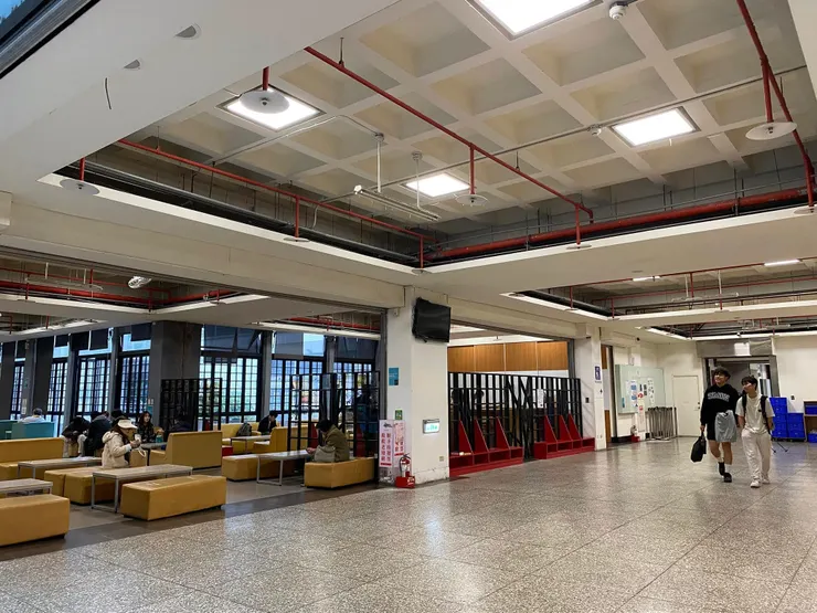 前後棟之間的通道區隔左右兩側不同的使用功能，右側為較吵雜的餐飲區，左側則是安靜的閱讀區。