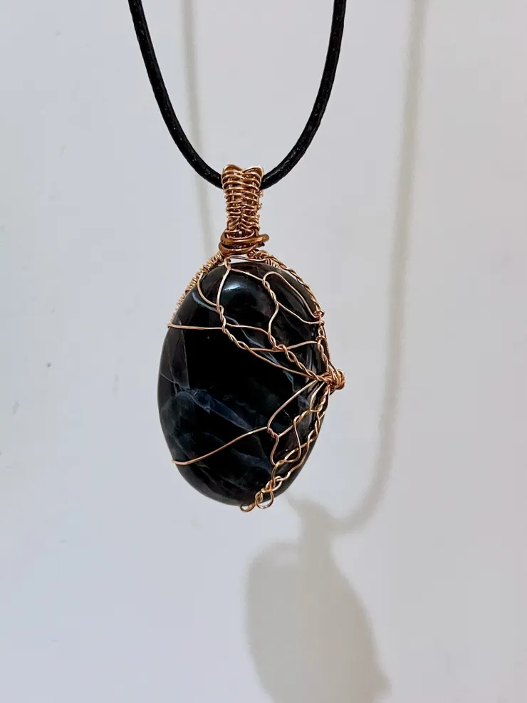 那抹在黑色礦石中隱現的光，與右側不對稱的蝴蝶翅膀，是祂作為「Abnormal 」的勳章。