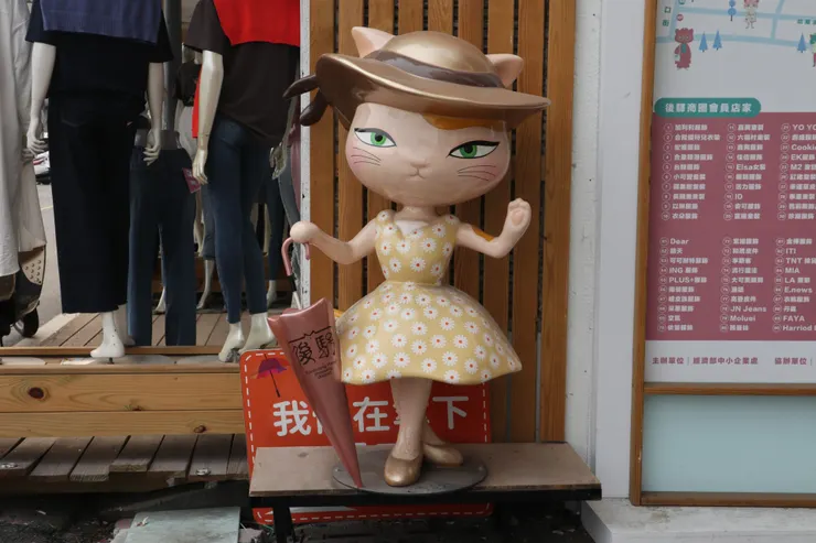 戴草帽穿花洋裝的貓咪,雨傘上還寫著後驛