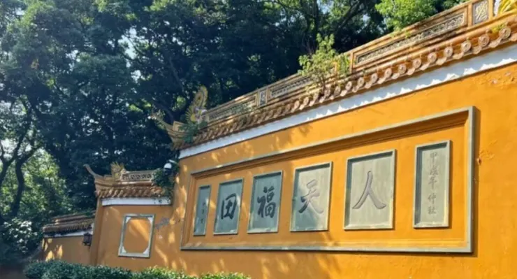 洛迦山牆面上刻著「人天福田」字樣，周圍被翠綠的樹木環繞，顯示出這座寺廟的寧靜氛圍。