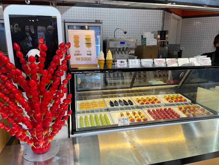 很繽紛的糖葫蘆店，口味很多店面大，仔細看還發現有鳳梨口味。很多人在買但我們最後沒有買這家。