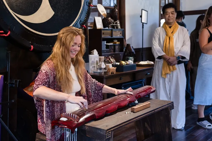 圖說：來自倫敦的網紅嘗試彈奏古典樂器，沉浸在台灣多元的藝術文化與匠人精神之中。（credit by photoammon）