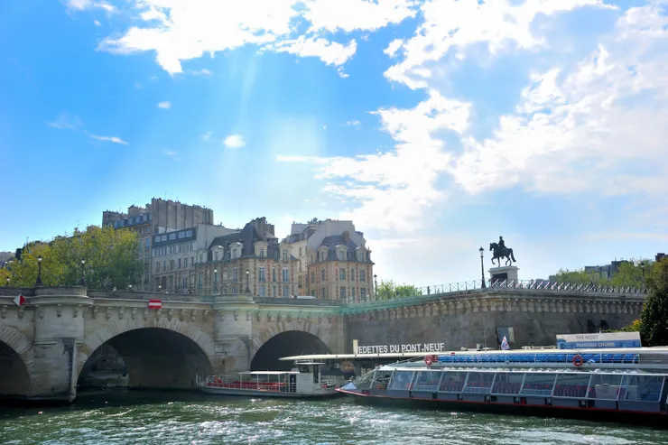 【船行河中左顧右盼指點建築橋樑！遠遠可見位於新橋上的亨利四世的騎馬雕像。】
