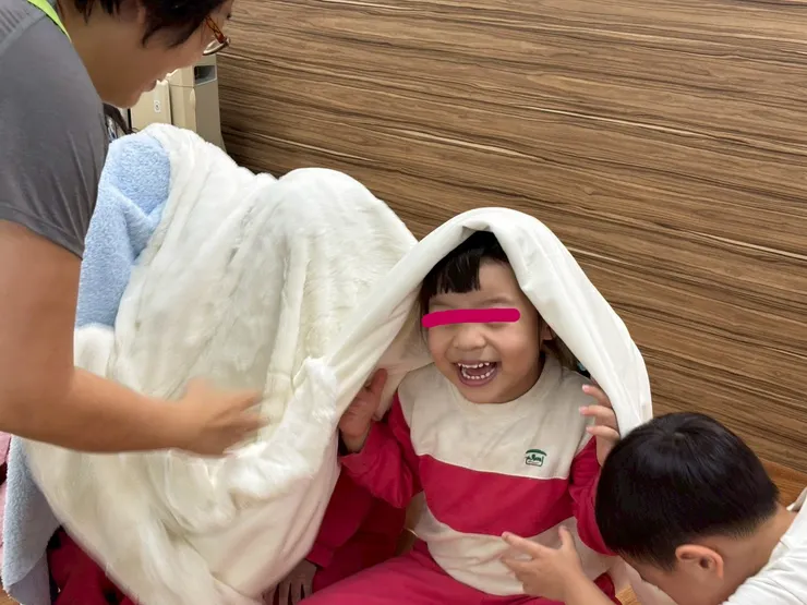孩子躲在毛毯下聽故事