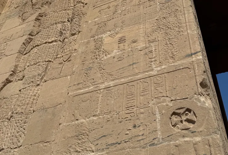 突兀的十字架深深的刻在牆上，對比一旁被抹去的壁畫身影