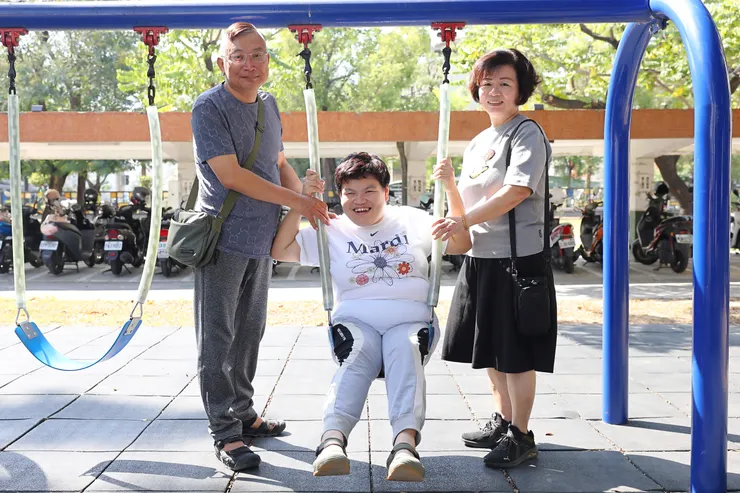 （圖說：校友尤淑惠(中)與爸爸、媽媽一同回到鳳山早療中心，開心地合影留念。）