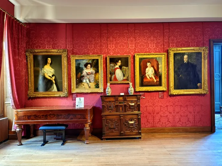 【紅色沙龍，雨果居住期間，是浪漫主義運動先鋒人物的重要聚會場所，包括泰奧菲爾·戈蒂耶（Théophile Gautier）、拉馬丁（Lamartine）、大仲馬（Dumas）等。牆上畫像由左而右為：妻子阿黛爾·富歇 (Adèle Foucher)、女兒蕾歐波蒂娜·雨果 (Léopoldine Hugo) 、女兒《拿櫻桃的阿黛爾》(Adèle à la cerise)、兒子弗朗索瓦-維克多·雨果 (François-Victor Hugo)、父親雨果將軍 (General Hugo)，即約瑟夫·雨果 (Joseph Hugo)。】