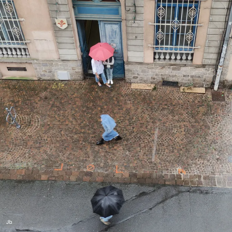 【靜觀雨街即景不無聊倒有趣！我就在窗邊拿著手機等待這些雨傘、雨衣客形成一直線。】