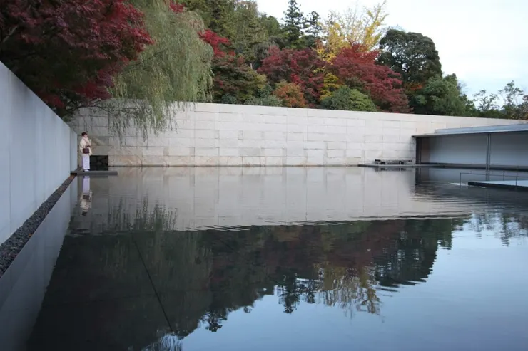 池水如鏡，倒映楓紅與山林線條。和服女子佇立，彷彿時間也沉靜下來。