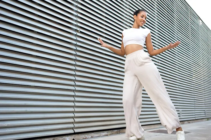 選擇一件貼身的短版背心或削肩上衣,大方露出相對纖細的肩頸線條。當視覺重點停留在纖細的上半身,運動寬褲的垂墜感就能順勢掩蓋下半身的肉肉。圖/123RF圖庫