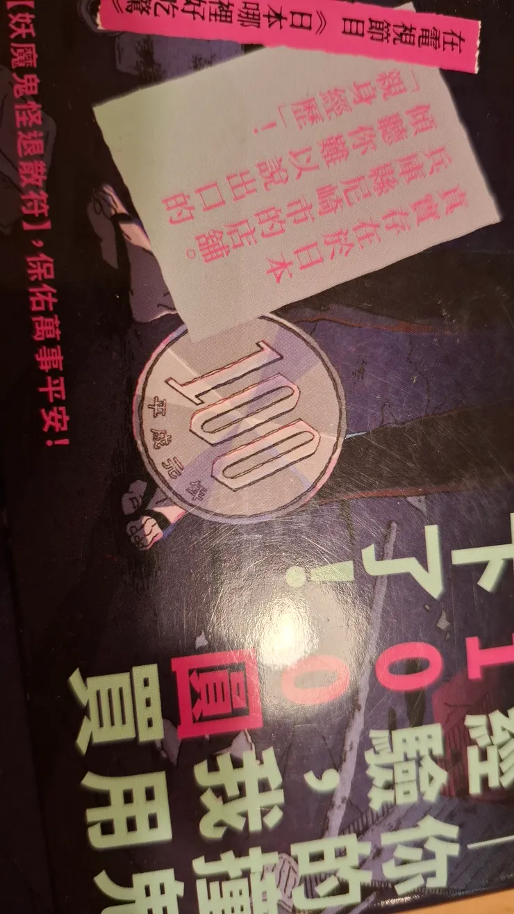 書腰有一個百元日圓硬幣，但是封面沒有。這是否意味著讀者買下怪談了？