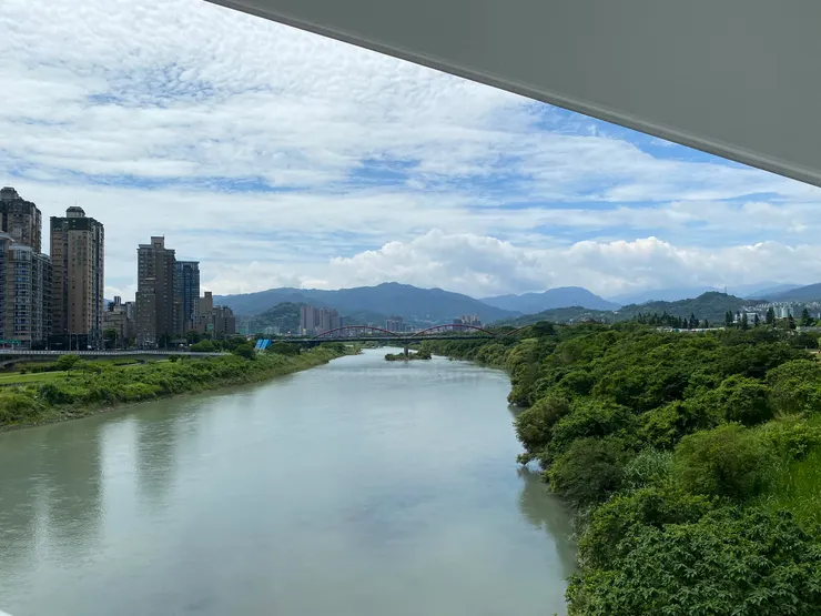 陽光橋跨越新店溪，遠遠看到一座水管橋。水管橋橋身都會漆成紅色以供辨識