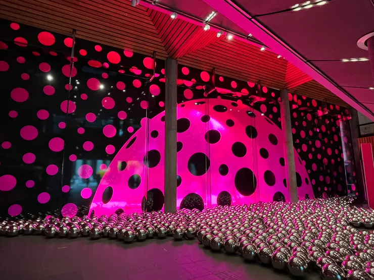 由水牆的背面拍攝,背景是草間彌生特展布置之一