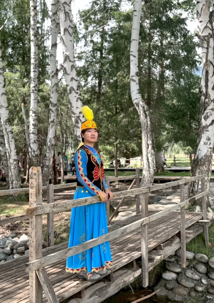 禾木村有一大片的白樺林，美麗的場景讓照片很有氛圍，女兒像不像一隻藍孔雀？