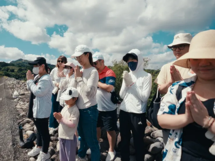 圖說：淨溪活動前後，參與民眾依照保育志工指示，雙手合十向山林環境表達敬意，不僅祈求順利、告知此行目的，更許下用心參與活動的承諾。（資料來源：貪貪Munchee）