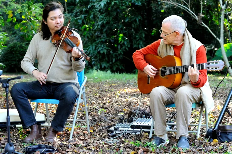 【木丹加鼓手風琴吉它古茹都擅長！此刻古茹又要求彈彈吉它，為唱誦聖名伴奏，正與小提琴手溝通曲目中。】