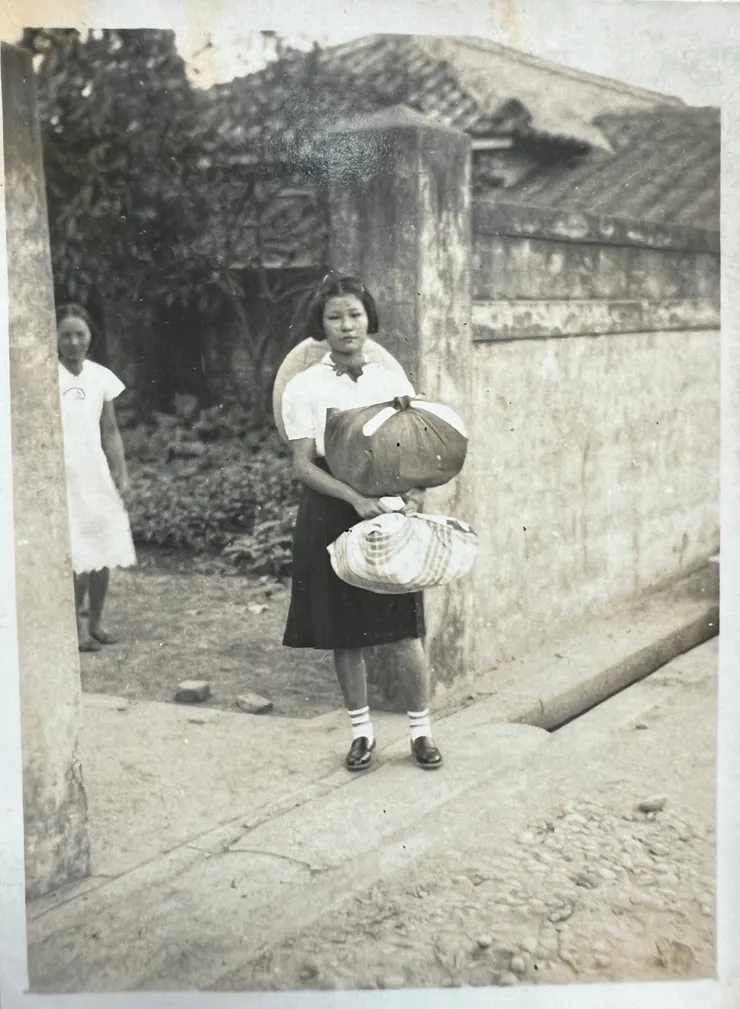 這是媽媽提著包袱要去唸醫事學校的照片。奶奶站於左後方。